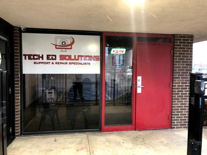 The entrance to TechEd and Solutions: the branded window reading Tech Ed Solutions, Support and Repair Specialists, a red door and a lit Open sign